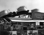 Hot dog on a stick 'Pronto Dog' joint. Waltzer ride in the background. 1948.