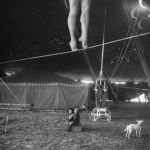 nina-leen-two-small-children-watching-circus-performer-practicing-on-tightrope-her-legs-only-visible.jpg